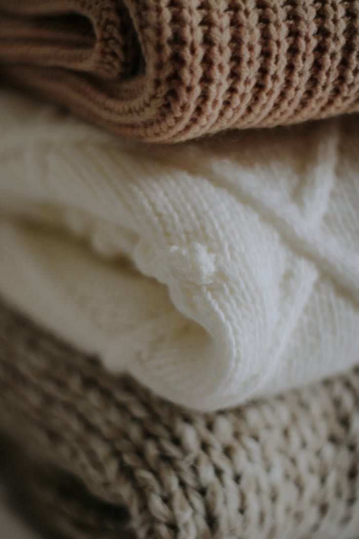services-02 Soft and textured stack of cozy knitwear, showcasing warm wool and handmade craftsmanship.